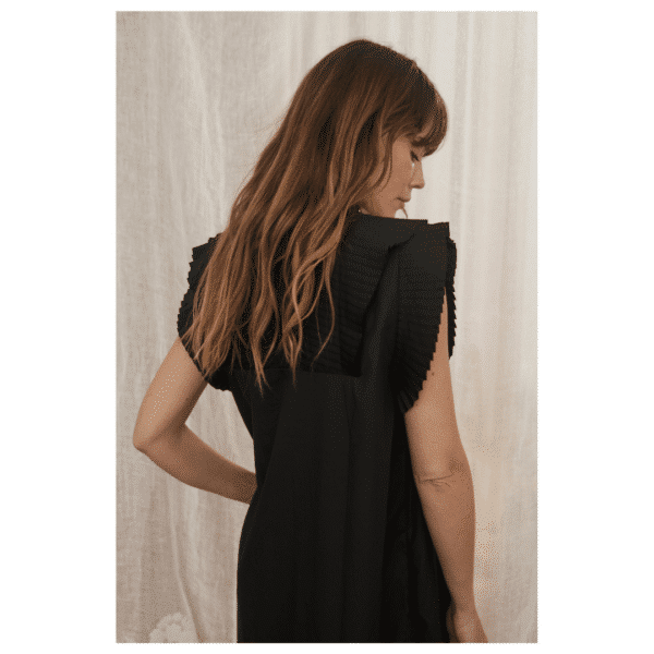 Milene Go kjole fra Gossia. En skøn sort kjole med flotte plissé flæser og en midi længde. 
