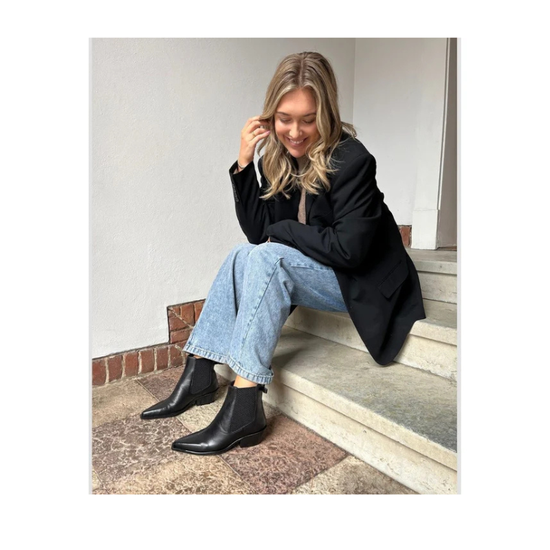 Just then støvle fra Copenhagen Shoes. En feminin og cool chelsea-støvle med et moderne twist. Modellen har klassisk elastik i siderne, som gør den nem at få af og på, og en elegant sløjfedetalje bagpå, der tilfører et unikt og stilfuldt udtryk.